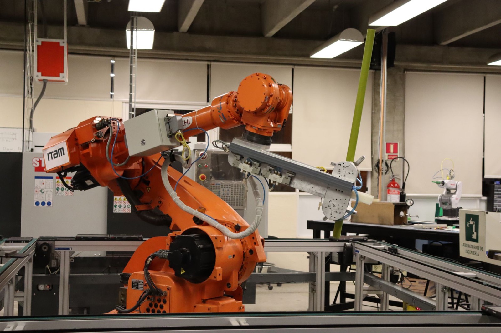 Technician operating a robotic welding arm on industrial equipment